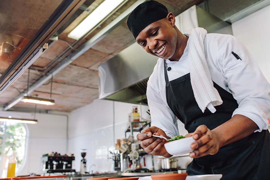 chef smiling and cooking in a commercial kitchen