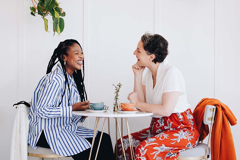 Two businesswomen chatting and laughing