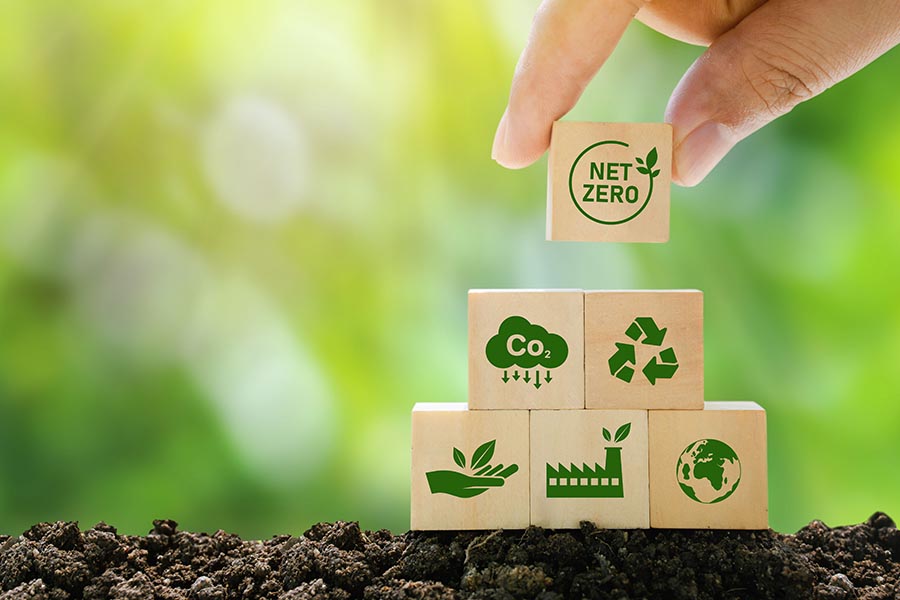 Net Zero and Carbon Neutral Concepts Net Zero Emissions Goals A climate-neutral long-term strategy Ready to put wooden blocks by hand with green net center icon and green icon on gray background.